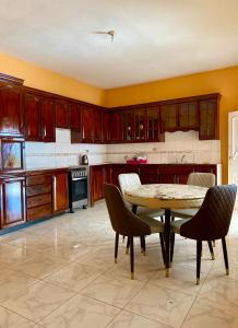 a kitchen with wooden cabinets and a table and chairs at Vista Oceanica in Ocho Rios