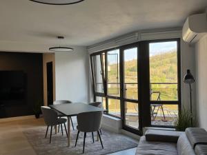 a living room with a table and chairs and a large window at View of the forest in Veliko Tŭrnovo