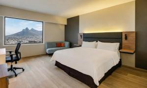 a hotel room with a large bed and a window at Fiesta Inn Monterrey Tecnologico in Monterrey +52 photos