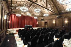 an empty auditorium with a red curtain and chairs at Hotel Arif Castle, Nainital in Nainital
