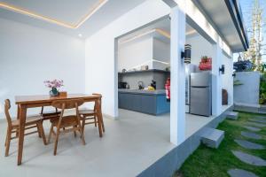 a kitchen and dining room with a table and a refrigerator at Majestic Balangan in Uluwatu