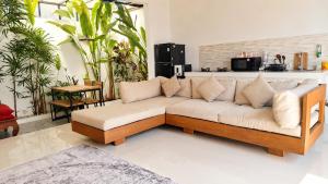 a living room with a couch and some plants at Tropical Villa with Swimming Pool in Selong Belanak
