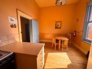 a kitchen with orange walls and a table and chairs at The Leopold Hotel in Ararat