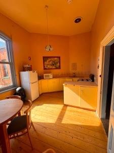 a kitchen with yellow walls and a table and a refrigerator at The Leopold Hotel in Ararat