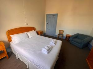 a bedroom with a bed with two towels on it at The Leopold Hotel in Ararat