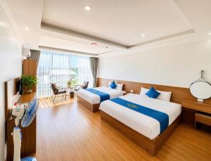 a hotel room with two beds and a desk at Ánh Sao Sapa Hotel in Sapa