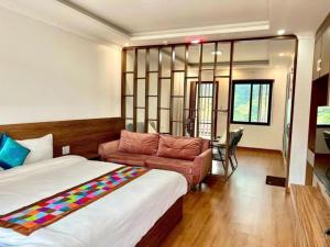 a hotel room with a bed and a couch at Ánh Sao Sapa Hotel in Sapa