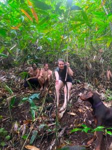 three people and a dog in the forest at FREEDOM HOUSE, Munnar - A Backpackers Hostel in Munnar