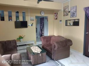 a living room with two leather chairs and a tv at Qiffah Homestay in Kuala Terengganu