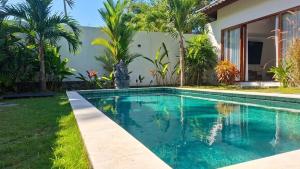 a swimming pool in the backyard of a house at Tropical Villa with Swimming Pool in Selong Belanak