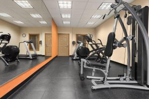 a gym with several treadmills and cardio machines at Country Inn & Suites by Radisson, Saraland, AL in Saraland
