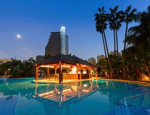 a swimming pool with a gazebo in front of a building at SOL by Meliá Príncipe in Torremolinos