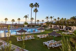a resort with a pool and chairs and palm trees at SOL by Meliá Príncipe in Torremolinos