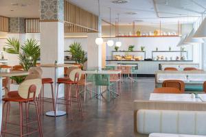 a restaurant with tables and chairs in a room at SOL by Meliá Príncipe in Torremolinos