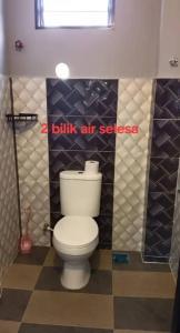 a bathroom with a white toilet in a room at Qiffah Homestay in Kuala Terengganu +9 photos