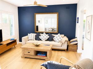 a living room with a couch and a mirror at Unique beach flat with own carpark area in Freshwater