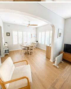 a living room with a table and a couch at Unique beach flat with own carpark area in Freshwater