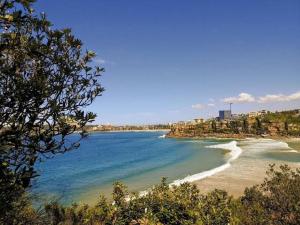 a view of a beach with buildings and the ocean at Unique beach flat with own carpark area in Freshwater