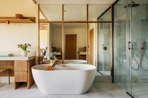 a bathroom with a tub and a glass shower at ME by Meliá Malaga in Málaga