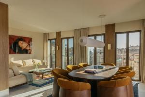 a living room with a table and chairs and a couch at ME by Meliá Malaga in Málaga
