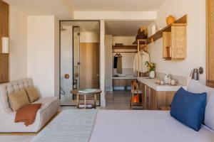 a bedroom with a bed and a couch and a kitchen at ME by Meliá Malaga in Málaga