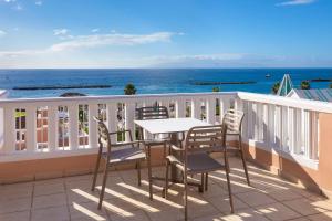 a balcony with a table and chairs and the ocean at SOL by Meliá Sun Beach Apartamentos in Adeje