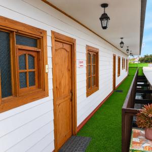 a row of doors on a house with grass at Apart Hotel Caldera - Room in Caldera