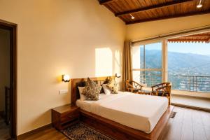 a bedroom with a bed and a large window at The Boho Shantii Stays in Bhīm Tāl