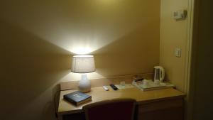 a desk with a lamp and a phone on it at Residence Club Inn in Nice