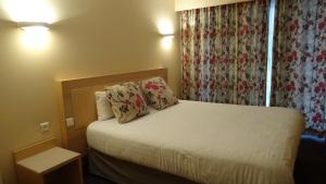 a hotel room with a bed with two pillows at Residence Club Inn in Nice