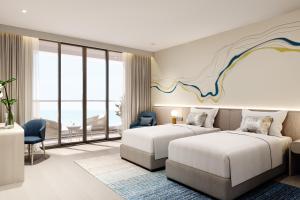 a hotel room with two beds and a view of the ocean at Meliá Aurea Nha Trang in Nha Trang
