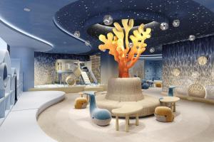 a room with a tree on the ceiling with stools at Meliá Aurea Nha Trang in Nha Trang
