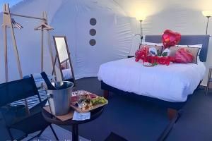 a room with a bed and a table with a plate of food at Open Sky Bubble for sleeping under the stars in Valparaíso