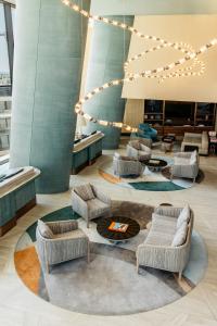 a lobby with chairs and a table and lights at ME by Meliá Malta in St. Julianʼs