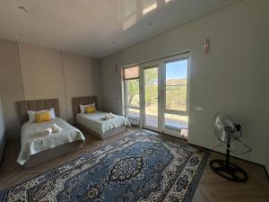 a bedroom with two beds and a fan and a rug at Mountain View in Türgen