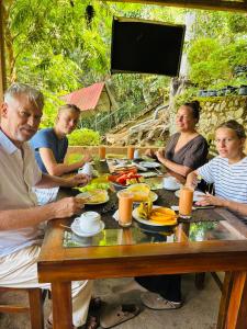 a group of people sitting at a table eating food at Ella Wood Cabin in Ella