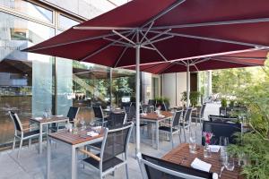 a restaurant with tables and chairs and an umbrella at Meliá Düsseldorf in Düsseldorf