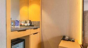 a small kitchen with yellow walls and a counter at Qingdao Elegance Hotel in Qingdao
