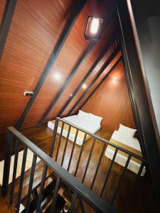 a room with two beds and a wooden wall at Arcadiaa Cabana in Polonnaruwa