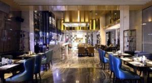 a restaurant with tables and blue chairs and a bar at Harbin Splendent Hotel in Shuangcheng