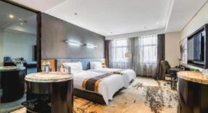 a bedroom with a large bed and two tables at Harbin Splendent Hotel in Shuangcheng +110 photos