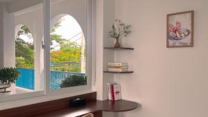 a room with two windows and a wooden desk at Lêu Hêu Villa & Coffee in Thôn Mỹ Phước