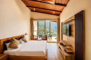 a bedroom with a bed and a large window at The Shantii Boho in Bhīm Tāl