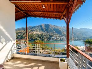 a balcony with a view of a lake and mountains at The Shantii Boho in Bhīm Tāl