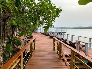 a wooden boardwalk leading to the water with birds on it at Hotel Roatán Media Luna Resort, Affiliated by Meliá in First Bight