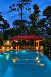 a swimming pool with a gazebo at night at SylVan Resort in Wayanad