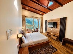 a bedroom with a bed and a television in a room at The Shantii Boho in Bhīm Tāl
