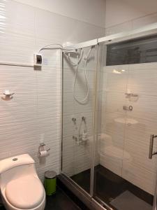 a bathroom with a shower and a toilet and a glass shower stall at Casa Munay in Huancayo +40 photos