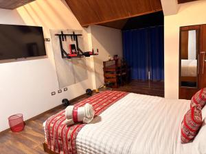 a bedroom with a bed with a tv on the wall at Casa Munay in Huancayo