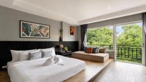 a bedroom with a large bed and a large window at JALMIN Hotel Samui in Chaweng